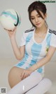 A woman in a soccer uniform holding a soccer ball.