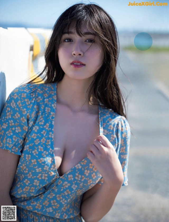 A woman in a blue dress posing for a magazine cover.
