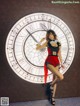 A woman in a red and black outfit posing in front of a clock.