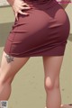 A woman in a skirt with a tattoo on her thigh.