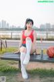 A woman sitting on a bench with a basketball.