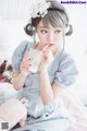 A woman sitting on a bed holding a glass of milk.